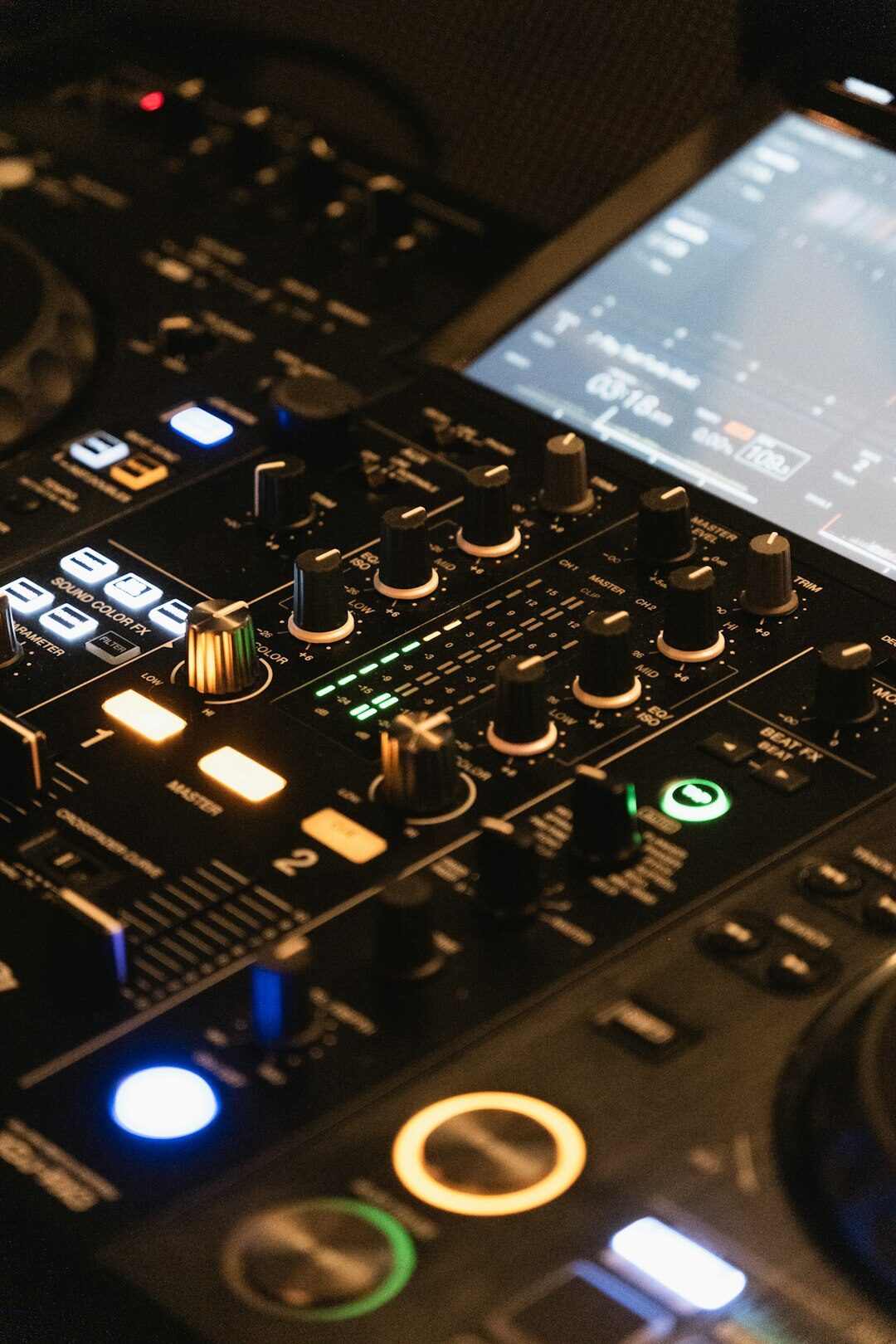 Audio mixing console with sliders and level meters in a sound booth