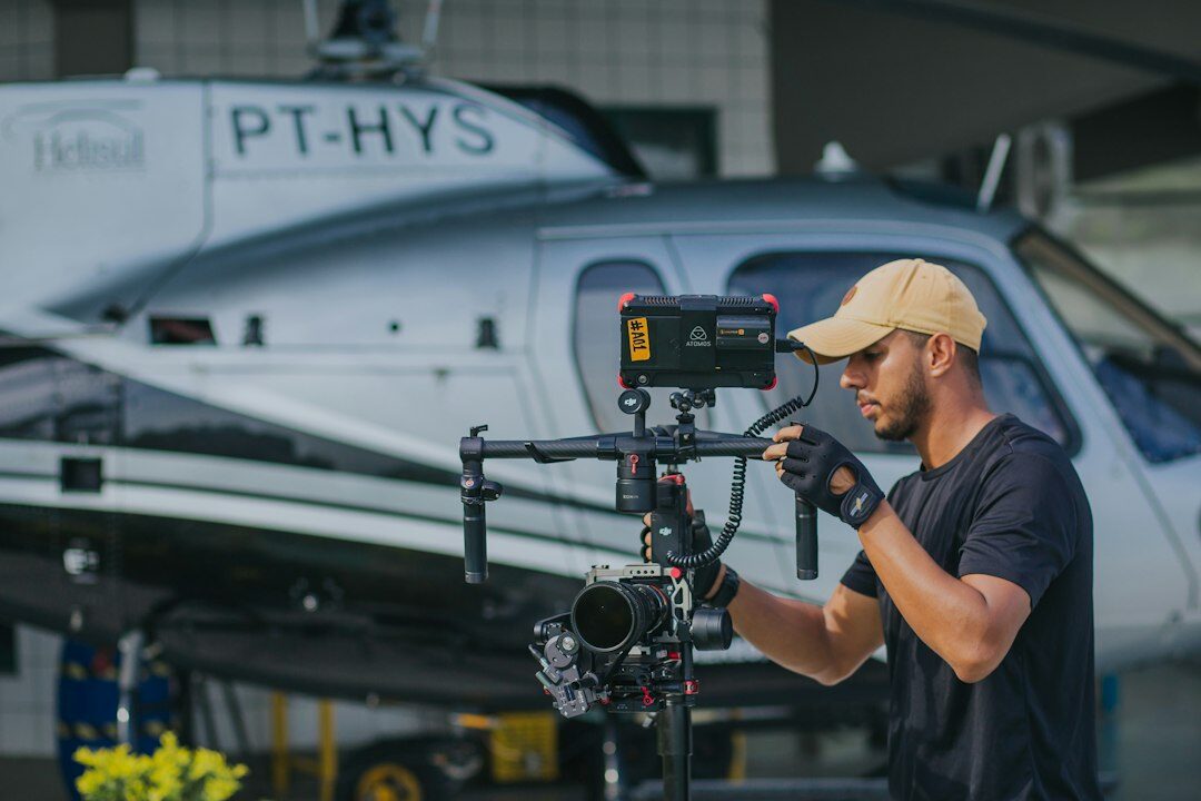 Camera operator adjusting a broadcast camera on a tripod